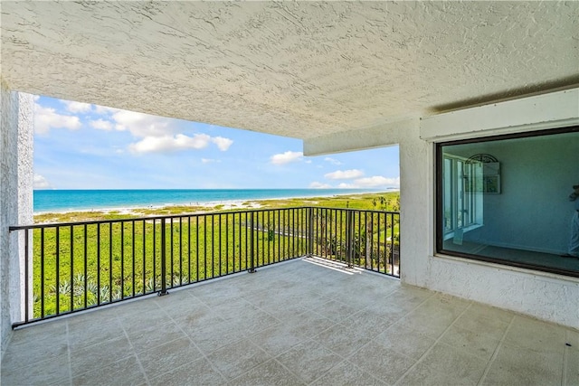 balcony featuring view of water and beach