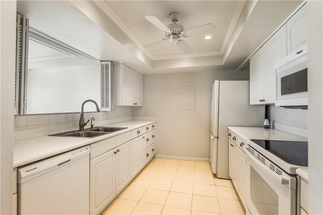 kitchen with white appliances, a sink, a raised ceiling, a ceiling fan, and light countertops