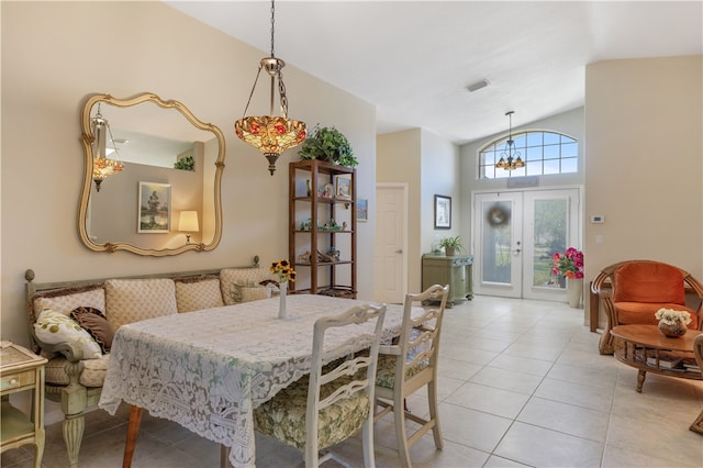 dining space featuring lofted ceiling, french doors, a notable chandelier, and light tile patterned flooring