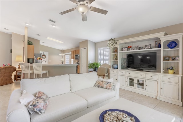 tiled living room with ceiling fan and vaulted ceiling