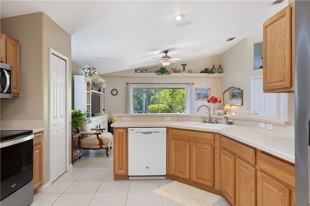 kitchen with stainless steel appliances, sink, ceiling fan, light tile patterned floors, and lofted ceiling