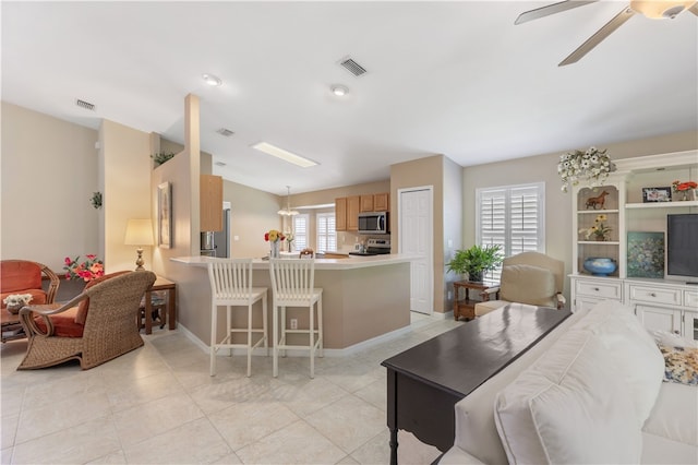 tiled living room featuring ceiling fan