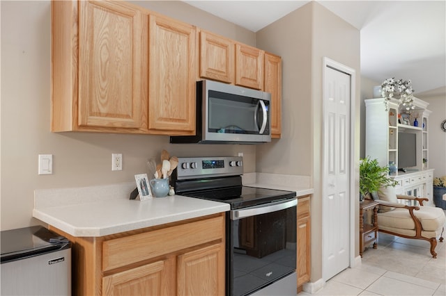 kitchen featuring light brown cabinets, stainless steel appliances, and light tile patterned floors