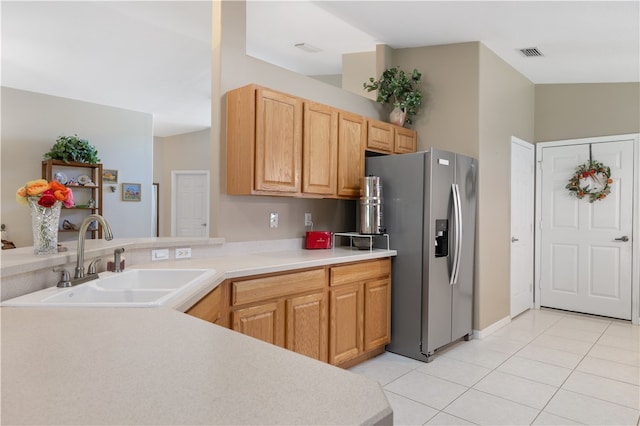 kitchen featuring light tile patterned floors, stainless steel fridge, and sink