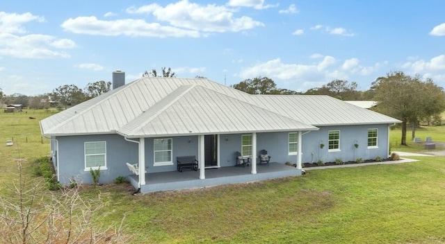 rear view of property featuring a patio area and a lawn