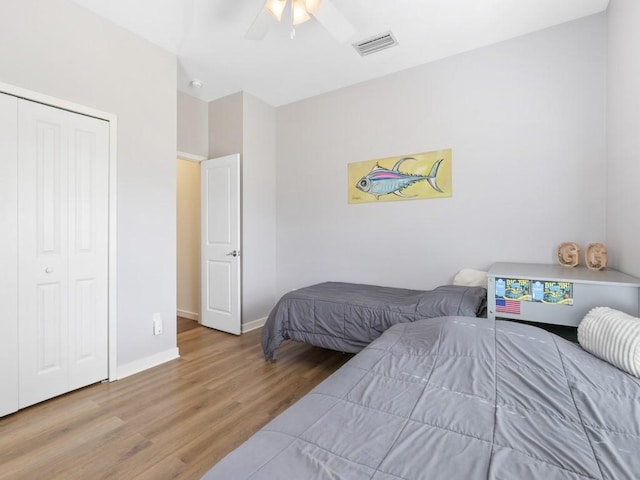 bedroom with wood-type flooring, a closet, and ceiling fan