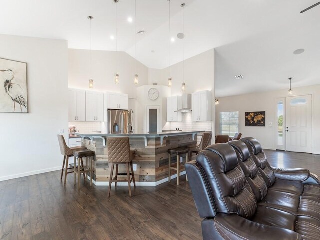 living room with dark hardwood / wood-style flooring and high vaulted ceiling