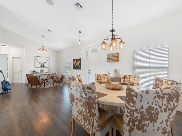 dining area with vaulted ceiling, dark wood-type flooring, and an inviting chandelier