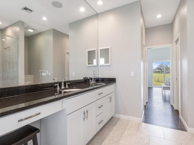 bathroom featuring vanity, a shower with shower door, and tile patterned flooring