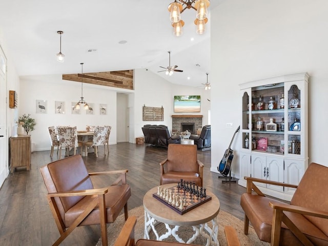 living room featuring lofted ceiling, dark hardwood / wood-style floors, and ceiling fan with notable chandelier