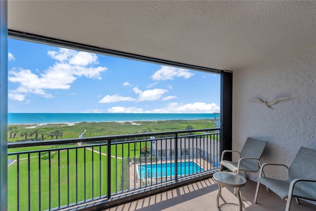 balcony featuring a water view and a beach view