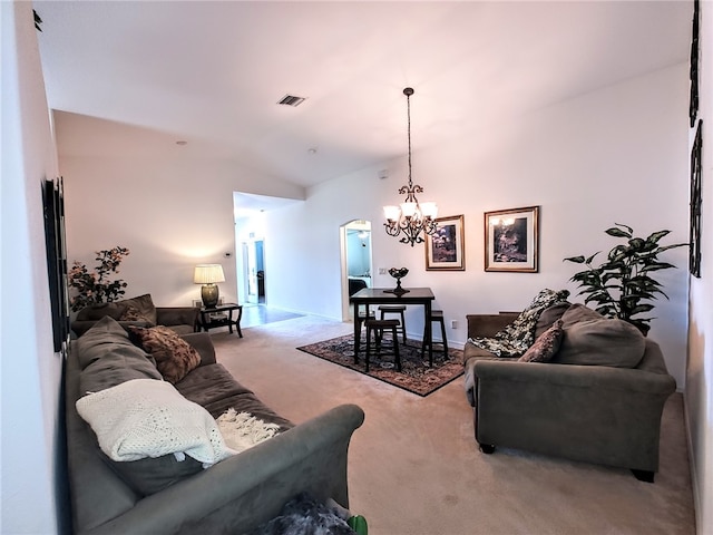 living room with carpet flooring, a chandelier, vaulted ceiling, and arched walkways