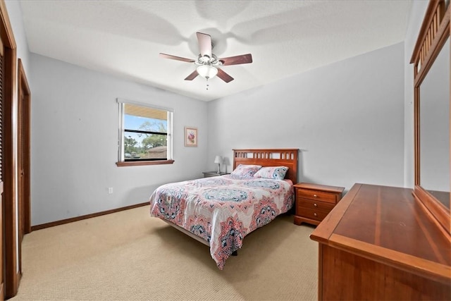 bedroom with light carpet, a closet, baseboards, and a ceiling fan