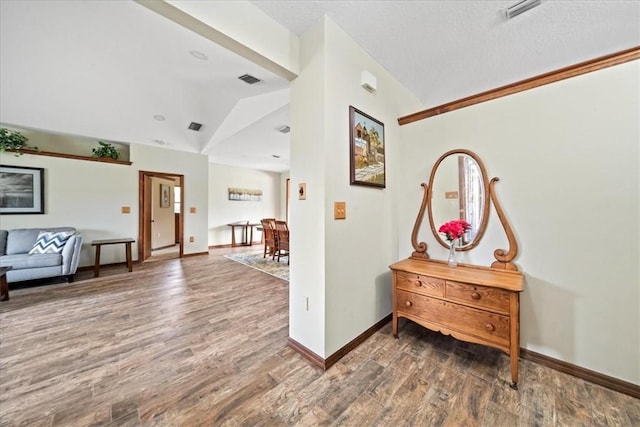 foyer entrance featuring wood finished floors, baseboards, and lofted ceiling