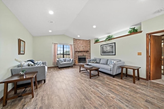 living area with baseboards, a brick fireplace, recessed lighting, wood finished floors, and lofted ceiling