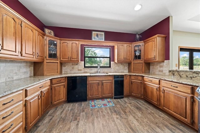 kitchen with a wealth of natural light, brown cabinets, a sink, and black dishwasher