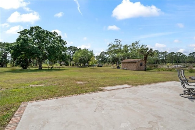 view of yard featuring a patio, a storage shed, and an outbuilding