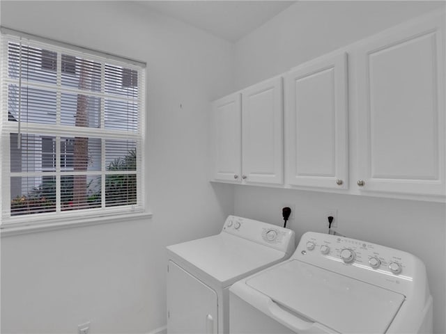 laundry area with washing machine and clothes dryer and cabinets