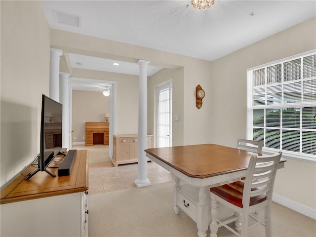 dining room with light carpet and decorative columns