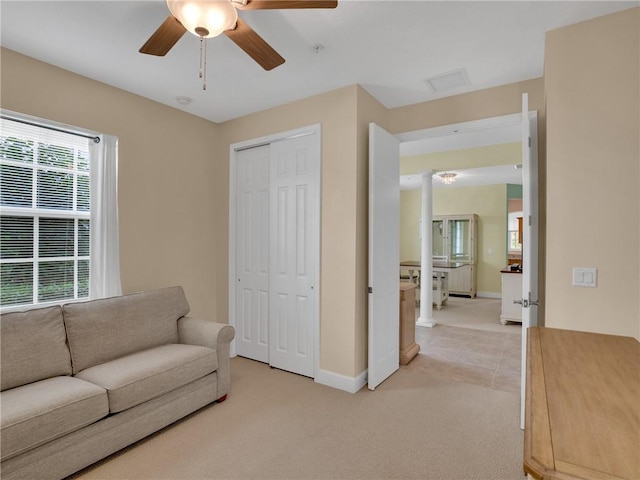 living area with ceiling fan and light colored carpet