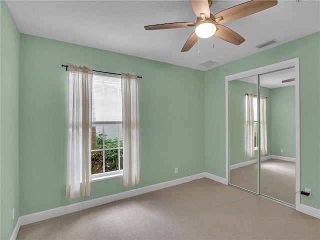 unfurnished bedroom with carpet floors, ceiling fan, and a closet