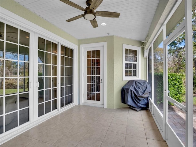 unfurnished sunroom with ceiling fan