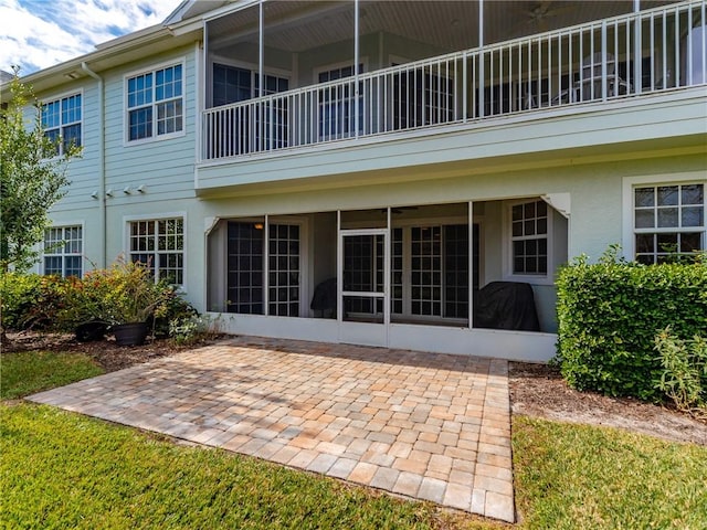 back of property with a patio and a sunroom