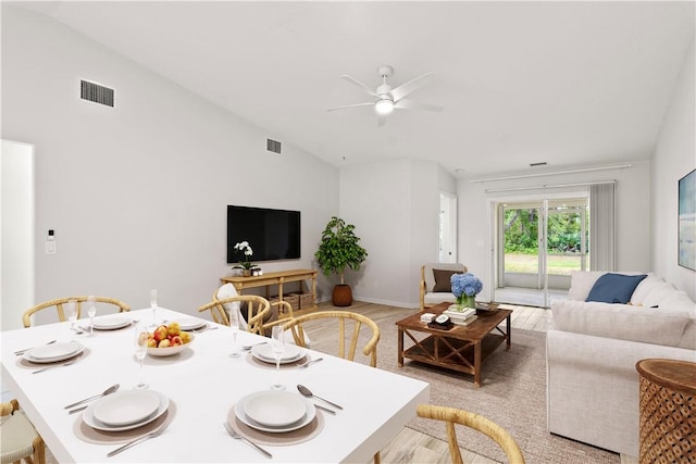 living area with vaulted ceiling, visible vents, light wood-style flooring, and a ceiling fan