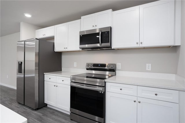 901 Brickell St SE, Palm Bay, FL 32909 - kitchen featuring appliances with stainless steel finishes, wood finished floors, white cabinetry, and recessed lighting