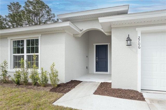 901 Brickell St SE, Palm Bay, FL 32909 - view of exterior entry with a garage and stucco siding