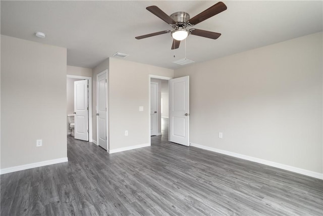 901 Brickell St SE, Palm Bay, FL 32909 - unfurnished bedroom with dark wood finished floors, connected bathroom, and a ceiling fan