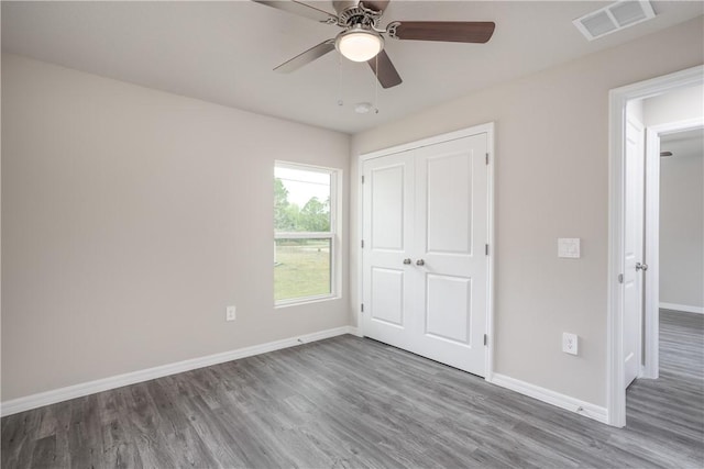 901 Brickell St SE, Palm Bay, FL 32909 - unfurnished bedroom with wood finished floors, a closet, and a ceiling fan