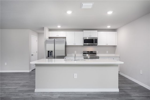 901 Brickell St SE, Palm Bay, FL 32909 - kitchen featuring appliances with stainless steel finishes, white cabinetry, light countertops, an island with sink, and recessed lighting