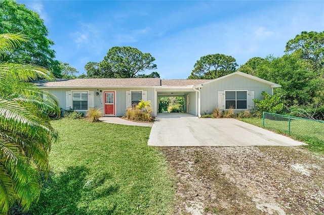 ranch-style home featuring a front lawn, a carport, driveway, and fence