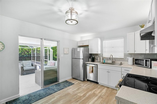 kitchen with light countertops, a healthy amount of sunlight, appliances with stainless steel finishes, and a sink