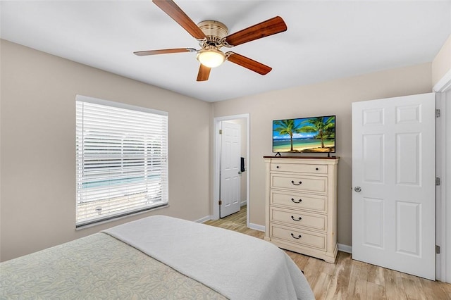 bedroom with baseboards, light wood-style floors, and a ceiling fan