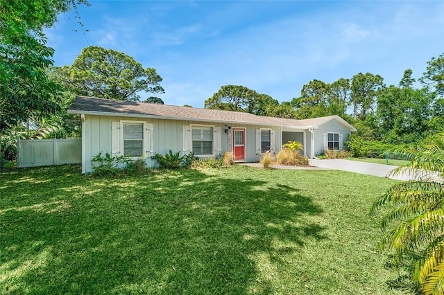 ranch-style home featuring a front yard, concrete driveway, and fence