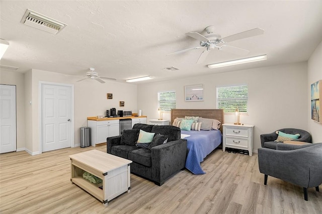 bedroom with visible vents, a textured ceiling, and light wood-style floors