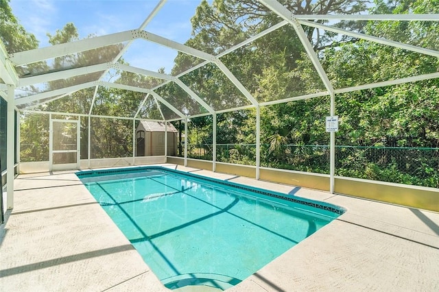 view of swimming pool with a lanai, fence, a fenced in pool, and an outdoor structure