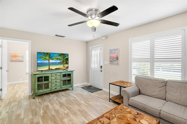 living room featuring plenty of natural light, light wood finished floors, and ceiling fan