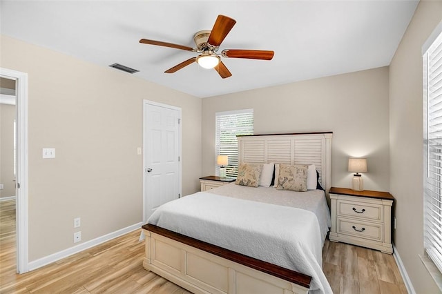 bedroom with ceiling fan, baseboards, visible vents, and light wood-type flooring