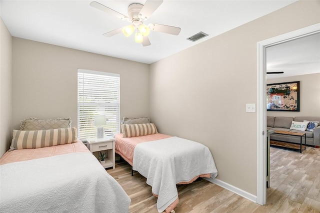 bedroom featuring visible vents, light wood-style flooring, baseboards, and ceiling fan