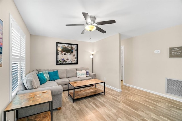 living area with light wood-style flooring, visible vents, baseboards, and ceiling fan