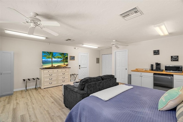 bedroom with fridge, visible vents, light wood finished floors, and ceiling fan