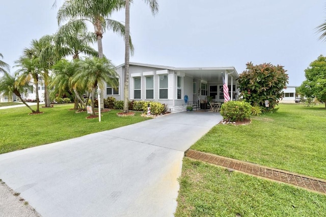 7648 Kyak Ct Unit Q16, Micco, FL 32976 - manufactured / mobile home with concrete driveway, a front yard, and an attached carport