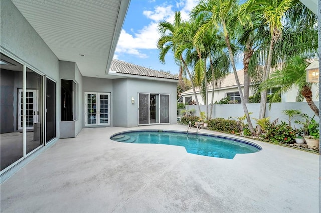 view of swimming pool featuring a patio, french doors, a fenced backyard, and a fenced in pool