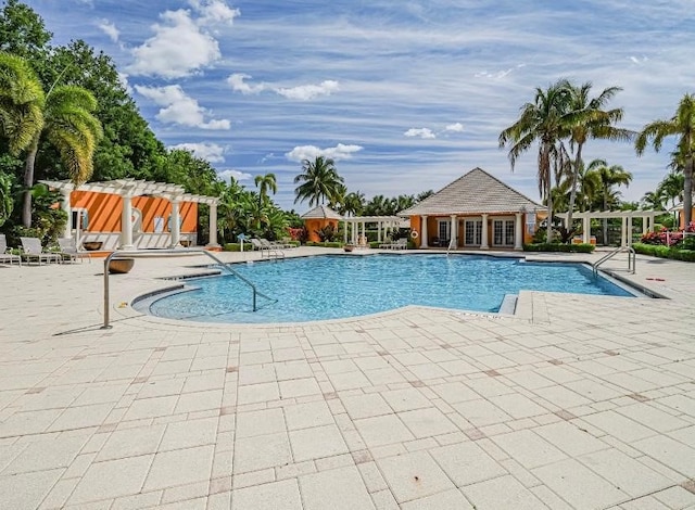 view of swimming pool featuring a patio and an outdoor structure