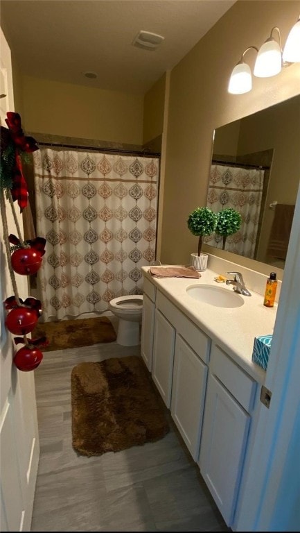 bathroom featuring vanity, curtained shower, and toilet