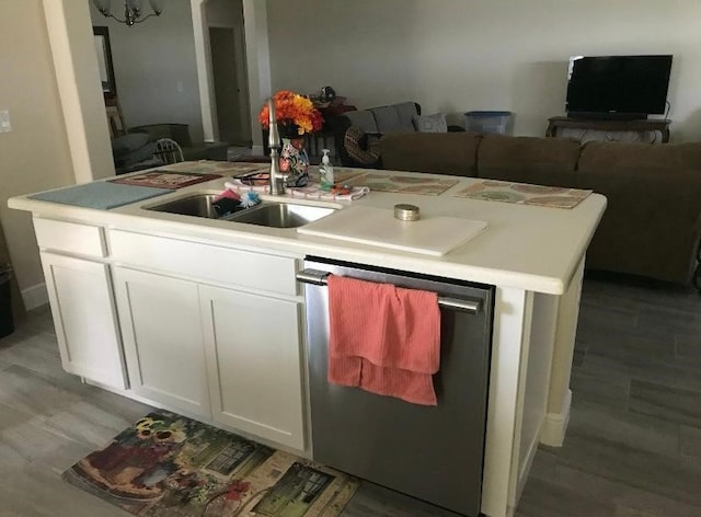 kitchen featuring white cabinetry, dishwasher, sink, light hardwood / wood-style flooring, and a center island with sink