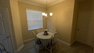 dining space with crown molding, dark hardwood / wood-style flooring, and a notable chandelier